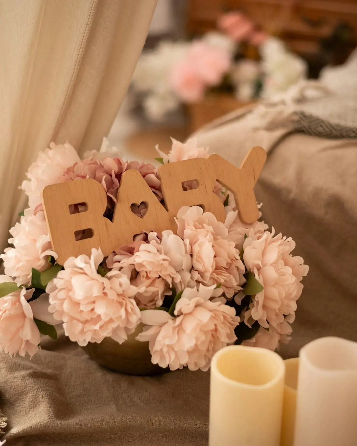 Soft pink flowers and wooden baby lettering arranged for a shower